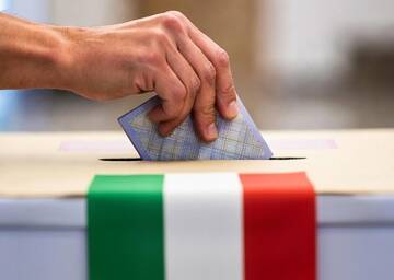 mano che inserisce la scheda elettorale nell'urna